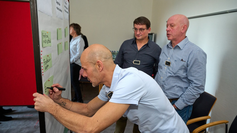Teilnehmer arbeiten an einer Pinwand, Workshop beim IHK Ausbilderforum