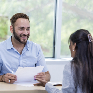 Ausbilder zusammen mit Auszubildender bei einem Übernahmegespräch